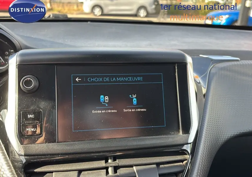 Écran central tactile du tableau de bord d'une Peugeot 208 noire perle métal, affichant le choix de manœuvre de stationnement.
