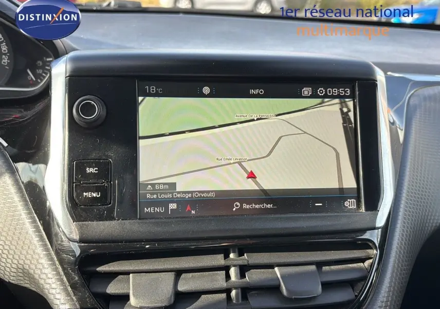 Écran tactile du système de navigation de la Peugeot 208 noire, vue centrale du tableau de bord avec commandes et ventilation.