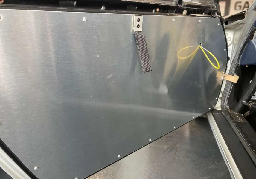 Vue rapprochée de la contre-porte en aluminium côté gauche d'une Porsche 911 3.0 SC gris métallisé de 1980, intérieur course.