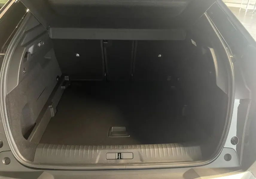 Coffre ouvert vu de l'arrière d'un Peugeot 3008 noir métallisé, montrant l'espace de chargement vide.