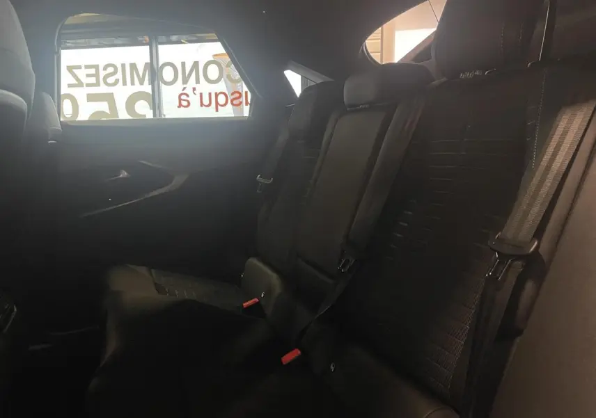 Vue intérieure côté droit des sièges arrière noirs du Peugeot 3008 1.2i Hybrid GT 2025 avec ceintures de sécurité visibles.