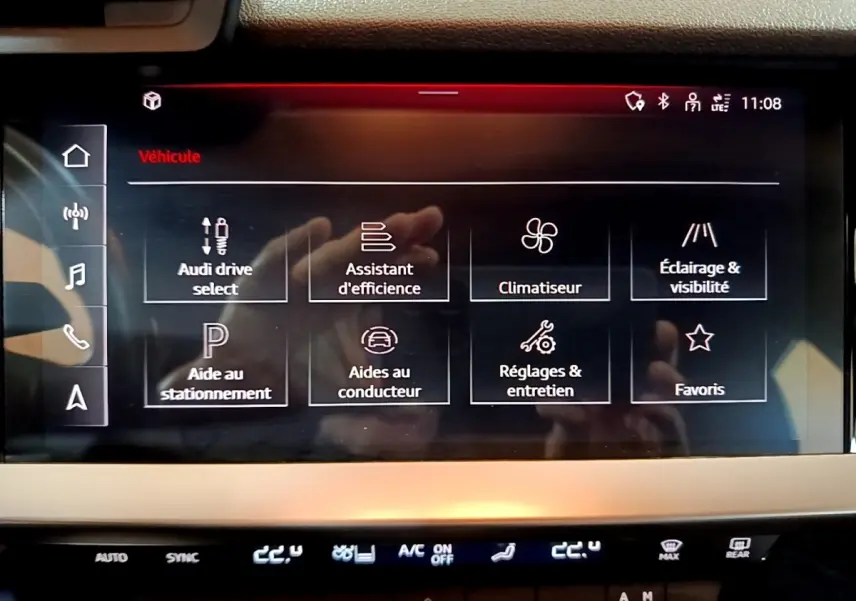 Écran tactile central de l’Audi A3 gris foncé, affichant le menu des aides à la conduite et réglages véhicule.