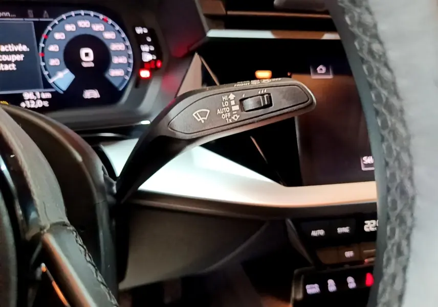 Gros plan sur le commodo d’essuie-glace côté gauche du tableau de bord gris foncé d’une Audi A3 35 TFSI 2021.