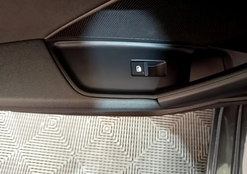 Détail de la commande de verrouillage de porte côté intérieur d’une Audi A3 gris foncé, vue rapprochée.