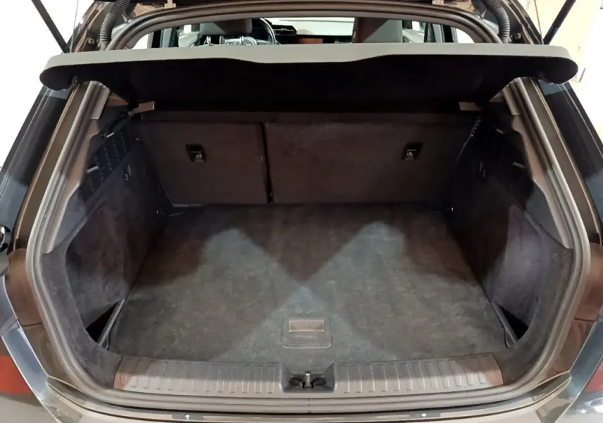 Vue arrière du coffre ouvert d'une Audi A3 gris foncé, montrant un espace de chargement propre et spacieux.