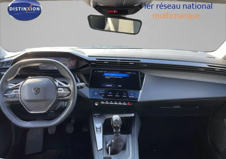 Vue intérieure avant du tableau de bord et volant de la Peugeot 308 bleu obsession avec boîte manuelle et écran tactile central.