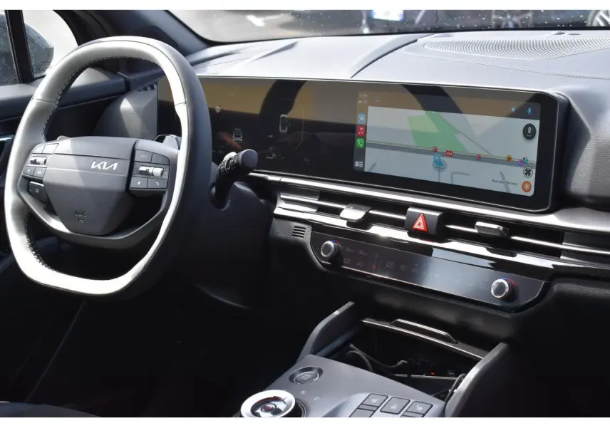 Vue intérieure du tableau de bord du Kia Sportage noir 2026, avec écran tactile large et volant multifonction.