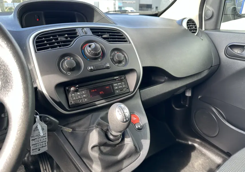 Vue intérieure côté passager du tableau de bord noir et levier de vitesses manuel d'un Nissan NV250 blanc de 2020.