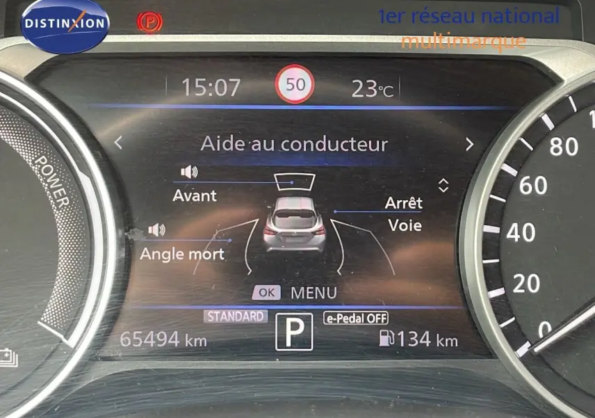Tableau de bord numérique du Nissan Juke gris perle, affichant l'aide au conducteur et la vitesse à 15h07.