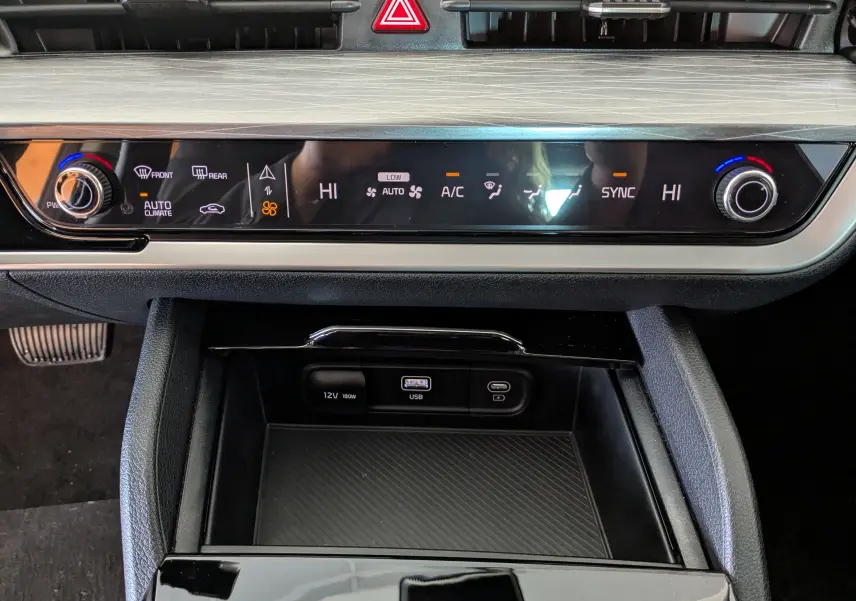 Détail de la console centrale du Kia Sportage MY25 blanc, montrant la climatisation automatique bizone et ports USB.
