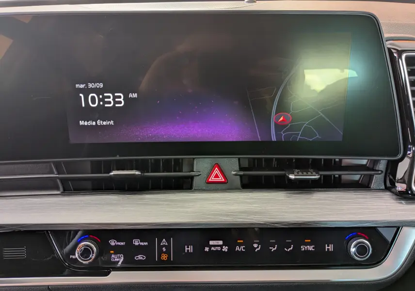 Vue rapprochée de l'écran tactile et de la console centrale du Kia Sportage blanc MY25 avec affichage GPS et commandes climatisation.