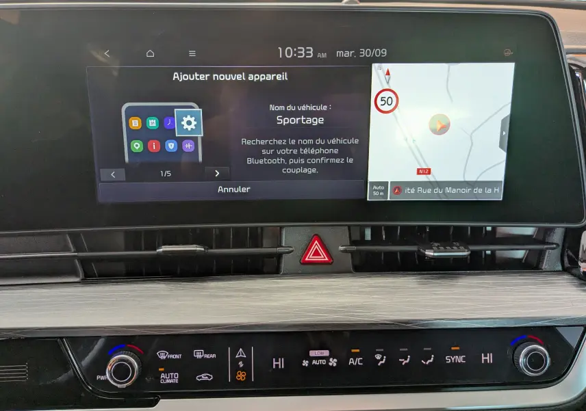 Écran tactile central du tableau de bord du Kia Sportage 2025 avec navigation et commandes climatisation bizone.
