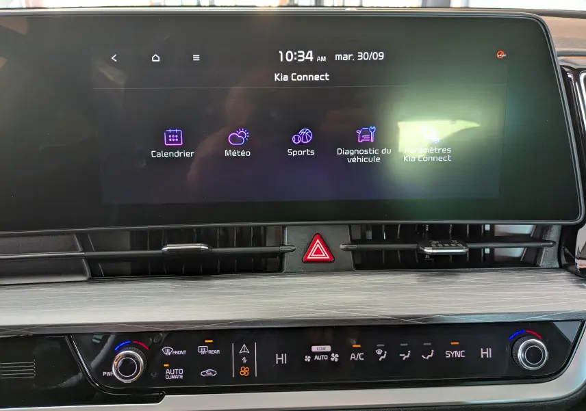 Écran tactile central du Kia Sportage MY25 blanc montrant l'interface Kia Connect et commandes de climatisation bizone.