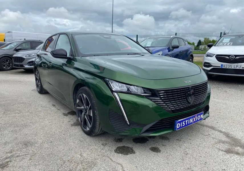 Peugeot 308 Vert Olivine vue 3/4 avant avec calandre noire et feux LED verticaux distinctifs.