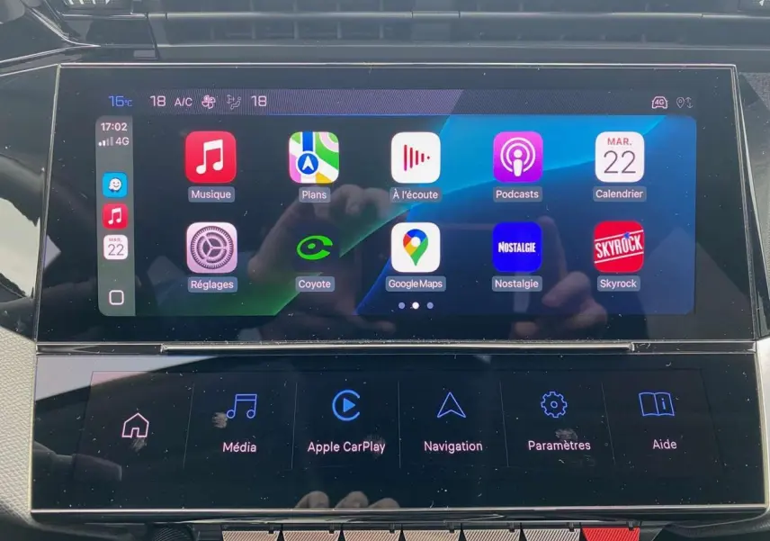 Écran tactile central de la Peugeot 308 2023 affichant Apple CarPlay et applications connectées.