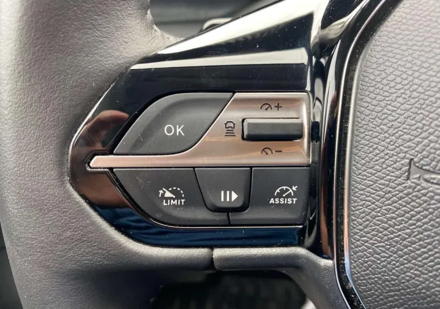 Gros plan sur les commandes de régulation de vitesse au volant de la Peugeot 308 2023 finition Allure Pack.