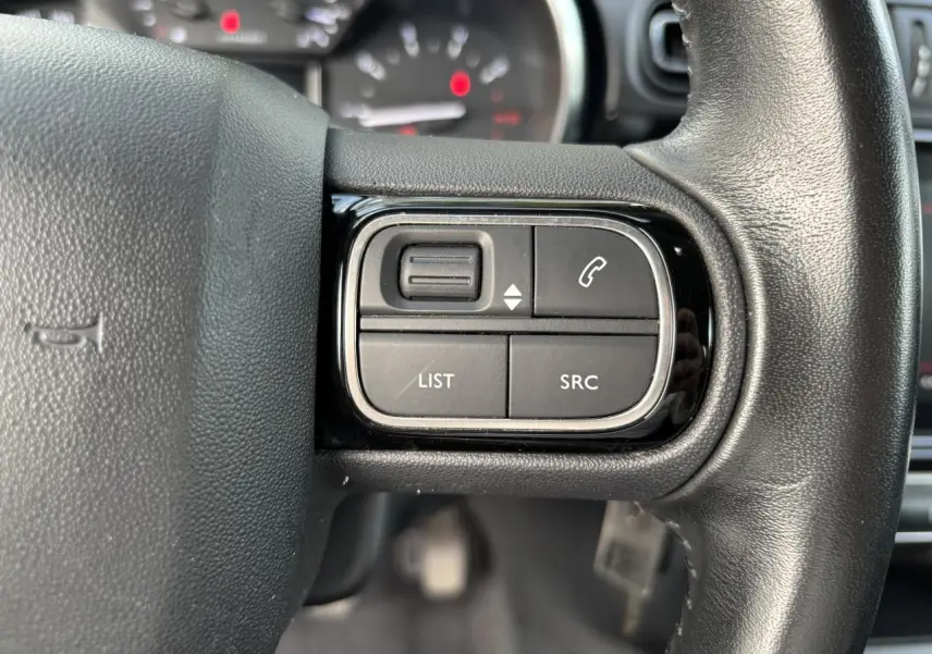 Gros plan sur les commandes audio et téléphone au volant noir de la Citroën C3 2019.