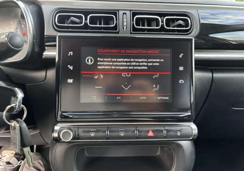 Vue rapprochée du tableau de bord noir de la Citroën C3 2019 avec écran tactile affichant un message d'absence de navigation.