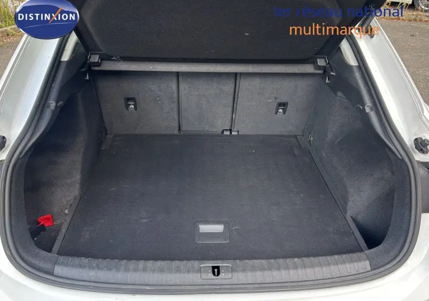 Coffre ouvert vu de l'arrière d'un Audi Q3 Sportback blanc 2021, montrant un espace de chargement propre et spacieux.