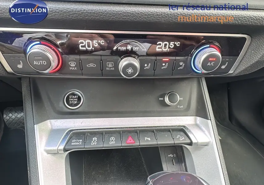 Gros plan sur la console centrale de l'Audi Q3 Sportback 2021, montrant les commandes de climatisation et le bouton start/stop.