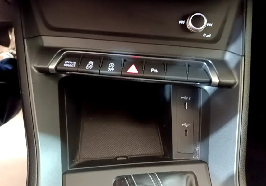 Vue rapprochée de la console centrale noire de l'Audi Q3 35 TFSI 2022 avec boutons de contrôle et ports USB.