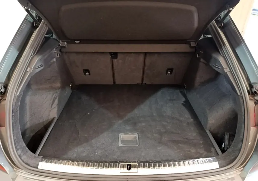 Coffre ouvert vu de l'arrière d'un Audi Q3 gris foncé, montrant un espace de chargement propre et spacieux.