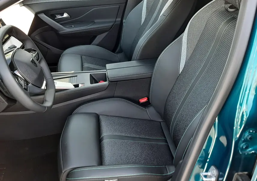 Vue intérieure côté conducteur de la Peugeot 308 2026, volant compact, tableau de bord numérique et écran central affichant la caméra 360°.