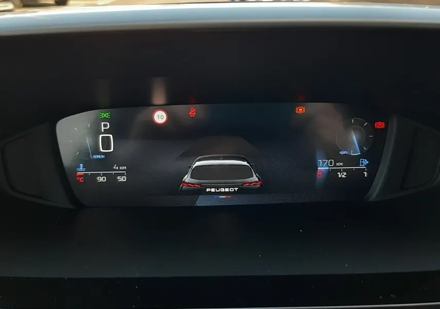Tableau de bord numérique de Peugeot 308 2026, affichage vitesse, régime moteur et autonomie, vue de face intérieure.