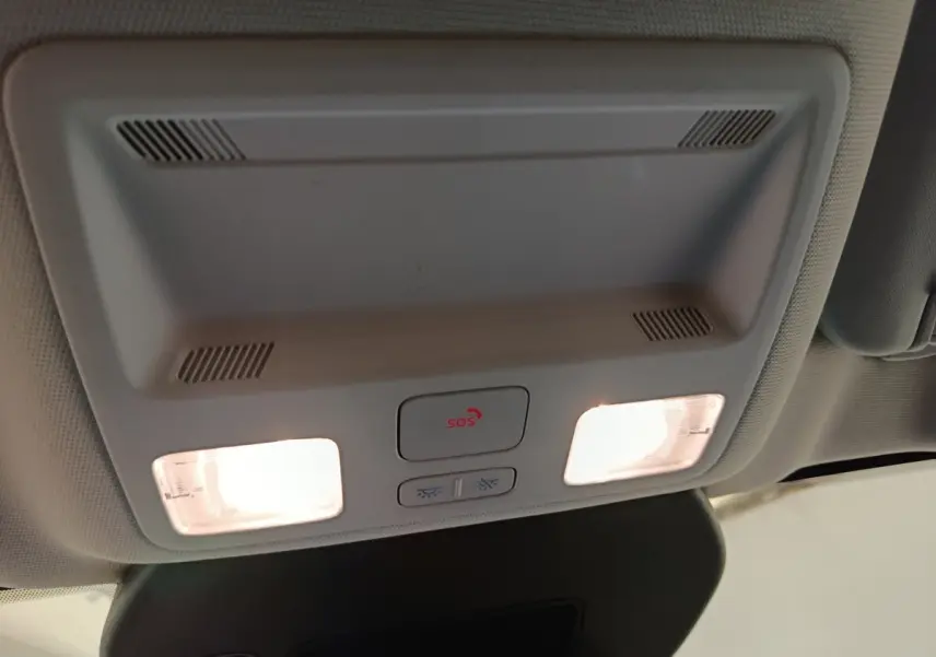 Vue intérieure du plafonnier gris clair du Ford Kuga 2023 avec éclairages et bouton SOS allumé.