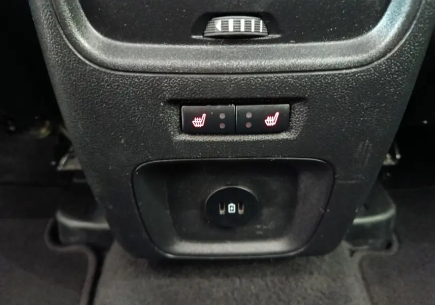 Gros plan sur les commandes de sièges chauffants arrière et prises USB du Ford Kuga gris foncé 2023, console centrale arrière.