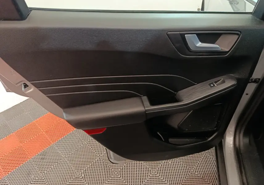 Vue rapprochée de la porte avant droite intérieure du Ford Kuga 2023, avec garniture noire et commande de vitre.