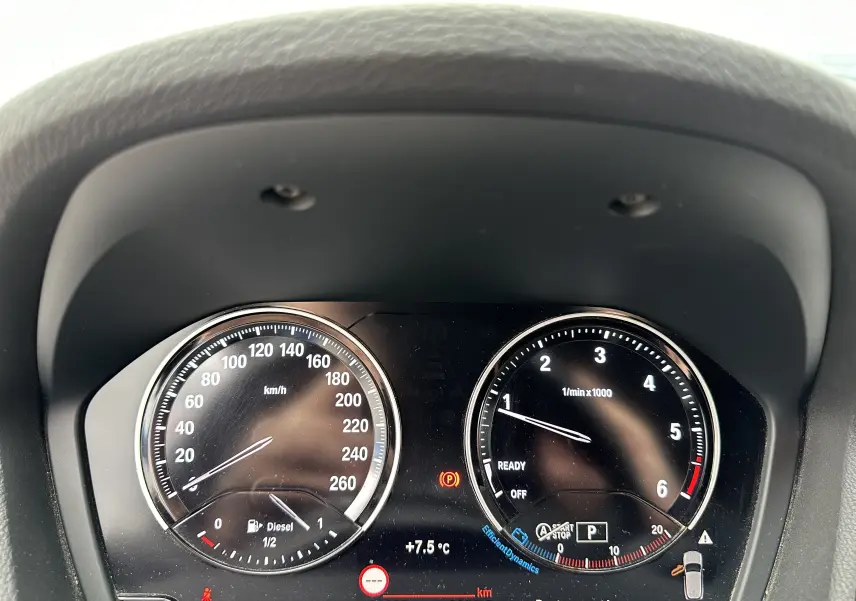 Tableau de bord du BMW X2 gris 2018 montrant la vitesse, le compte-tours et un avertissement de porte ouverte.