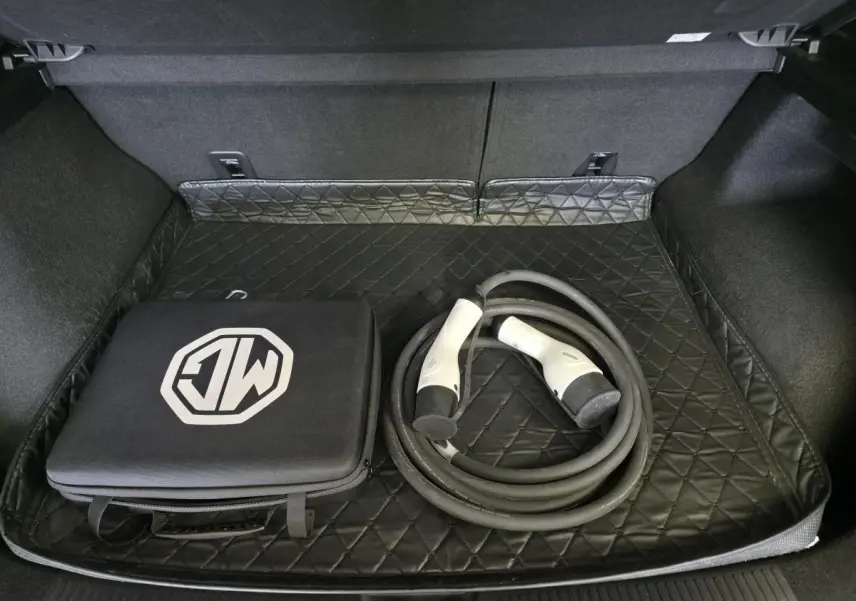 Coffre ouvert du MG4 électrique 2022 avec tapis matelassé noir, câble de recharge et sac de rangement MG.