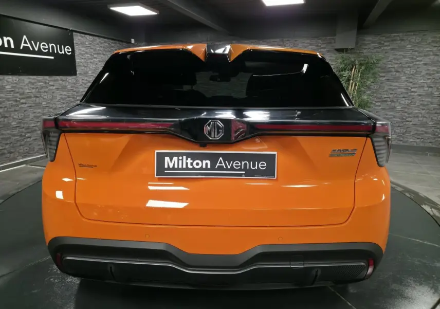 Vue arrière du MG4 électrique orange avec toit noir et bandeau lumineux LED intégrée au hayon.