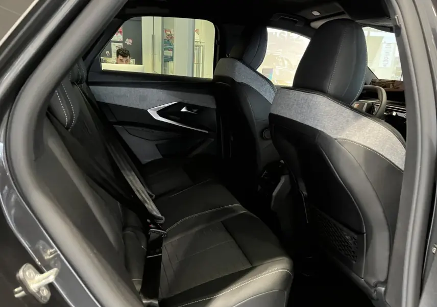 Vue intérieure côté gauche des sièges arrière en cuir noir et tissu gris du Peugeot 3008 GT gris titanium 2025.