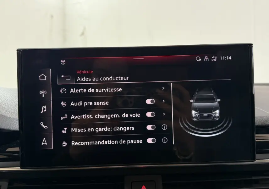 Écran tactile central affichant les aides au conducteur avec une vue avant stylisée d’une Audi A4 gris foncé.