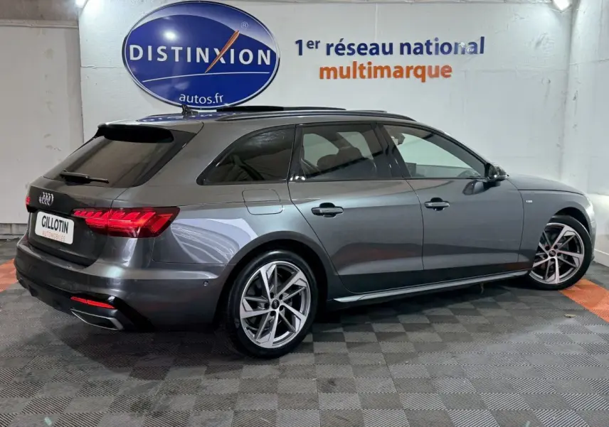 Audi A4 35 TFSI S Edition gris foncé vue 3/4 arrière droit, avec jantes alliage et feux LED allumés.