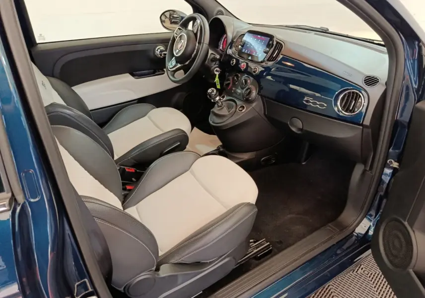 Vue intérieure côté conducteur de la FIAT 500 Hybrid bleu, avec sièges bicolores et tableau de bord brillant 500.