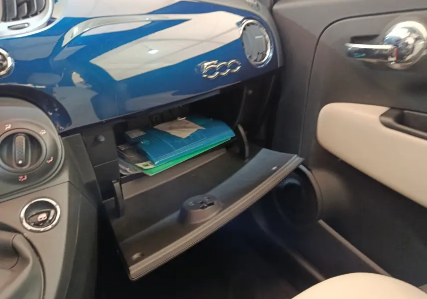 Vue intérieure côté passager du coffre à gants ouvert sur tableau de bord bleu brillant de la Fiat 500 Dolcevita 2022.