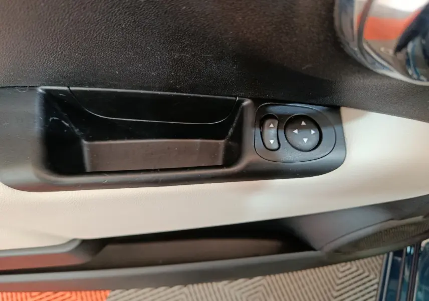 Gros plan sur la commande de réglage des rétroviseurs côté conducteur, intérieur bicolore noir et beige du FIAT 500 bleu.