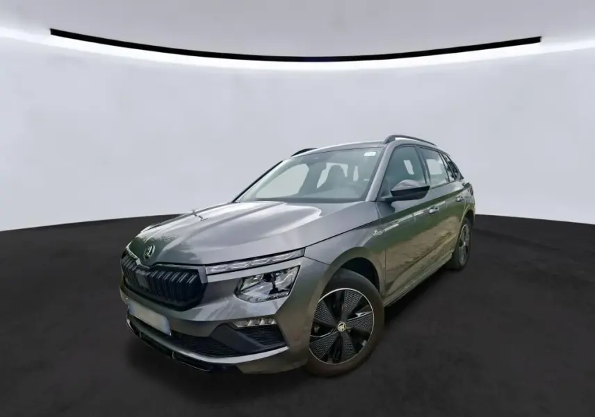 Vue 3/4 avant droit d’un Skoda Kamiq 1.5 TSI 150 DSG7 Monte-Carlo gris foncé avec jantes noires distinctives.