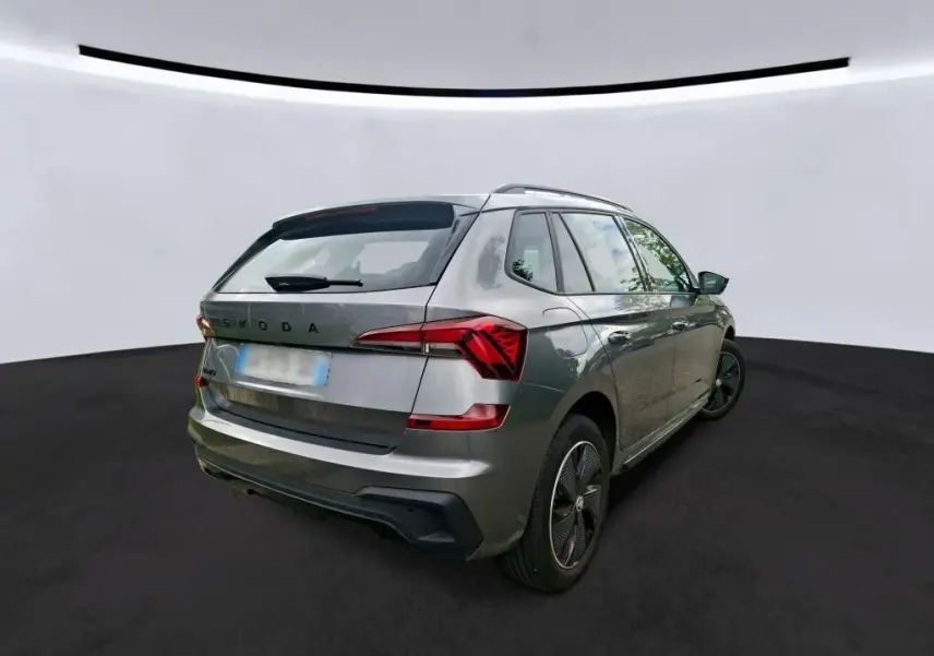 Vue 3/4 arrière droite d’un Skoda Kamiq gris foncé 2024 avec finition Monte-Carlo et jantes spécifiques.