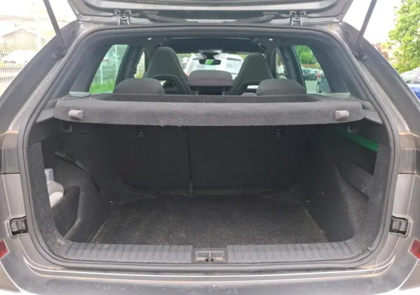 Coffre ouvert vu de l'arrière d'un Skoda Kamiq gris foncé 2024, montrant l'espace de chargement et la plage arrière.