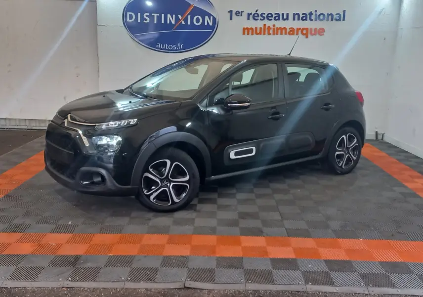 Citroën C3 BlueHDi 100 BVM PLUS noire vue de profil droit en intérieur avec jantes distinctives et protections latérales.