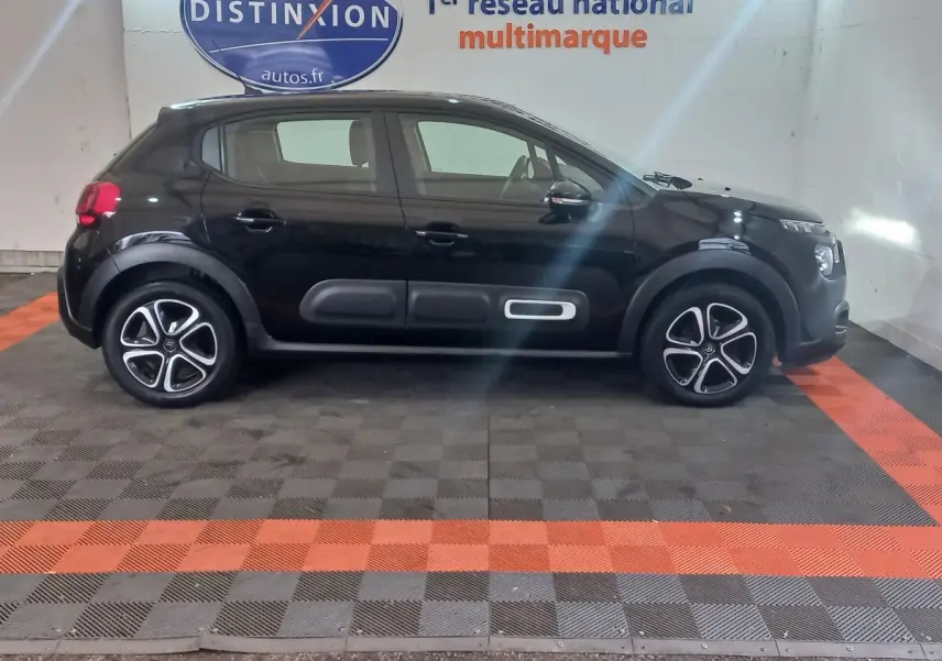 Citroën C3 noire vue de profil côté gauche, avec protections latérales caractéristiques et jantes stylisées.