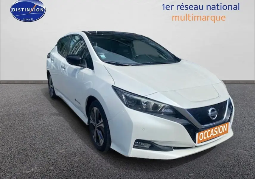 Nissan Leaf électrique blanc nacré vue 3/4 avant droit, toit noir et calandre distinctive avec logo Nissan.