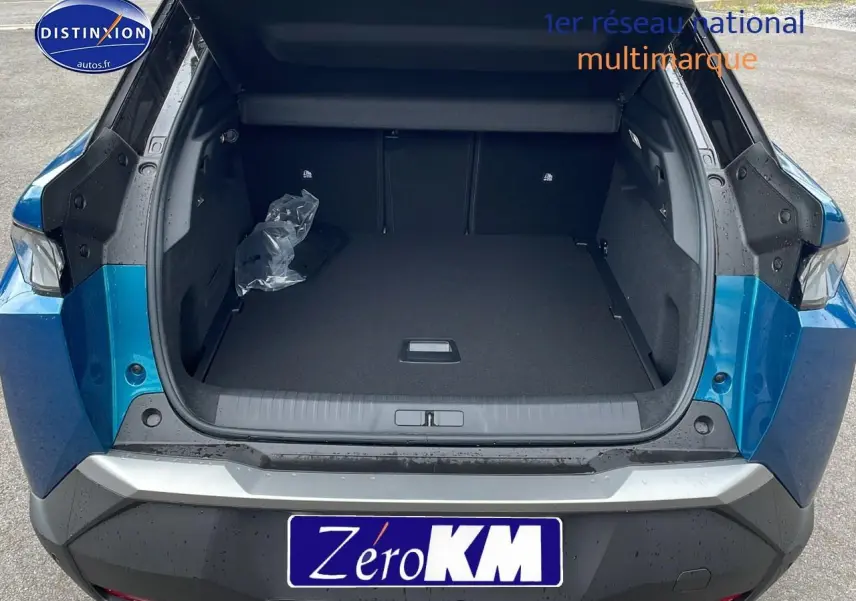 Coffre ouvert en vue arrière d'un Peugeot 3008 Hybrid 145 GT e-EAT8 bleu obsession avec hayon motorisé visible.