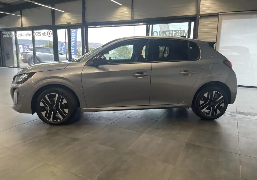 Vue de profil côté gauche d'une Peugeot 208 gris Artense avec jantes alliage 16 pouces en intérieur showroom.