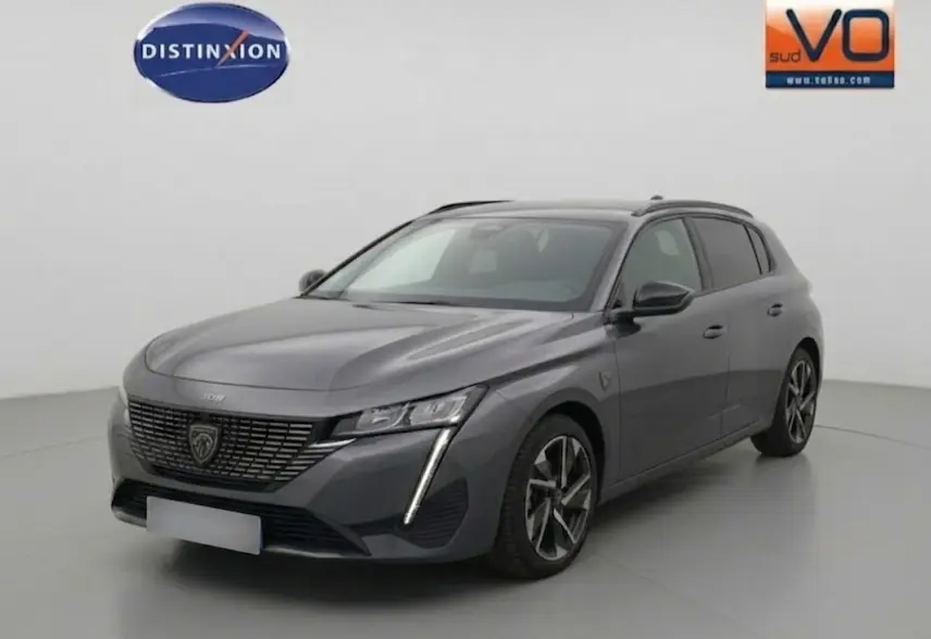 Peugeot 308 Hybrid gris vue 3/4 avant droit, jantes alliage 17 pouces et signature lumineuse verticale LED.