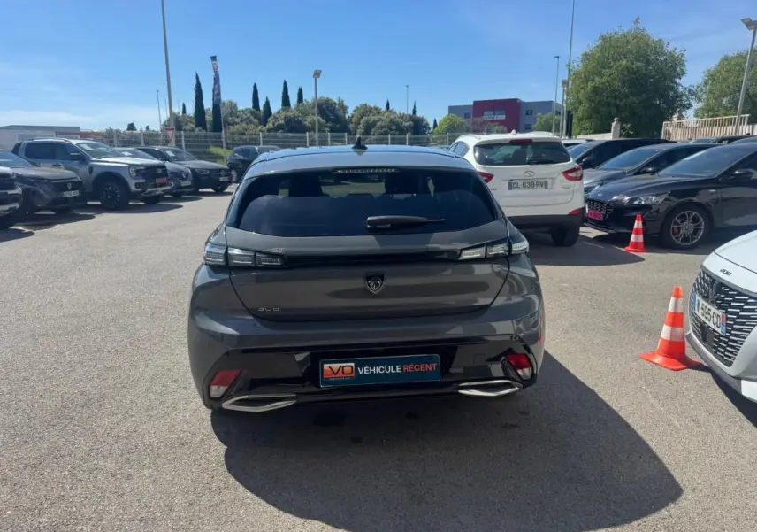 Vue arrière d'une Peugeot 308 Hybrid gris métallisé avec feux LED et double sortie d'échappement intégrée.